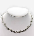 Black barbed necklace by 2KWRLD featuring sharp metal spikes on a chain, styled for a bold, edgy look.