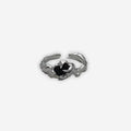Close-up of a 2KWRLD claw ring featuring a detailed, edgy design with metallic finish on a plain background.