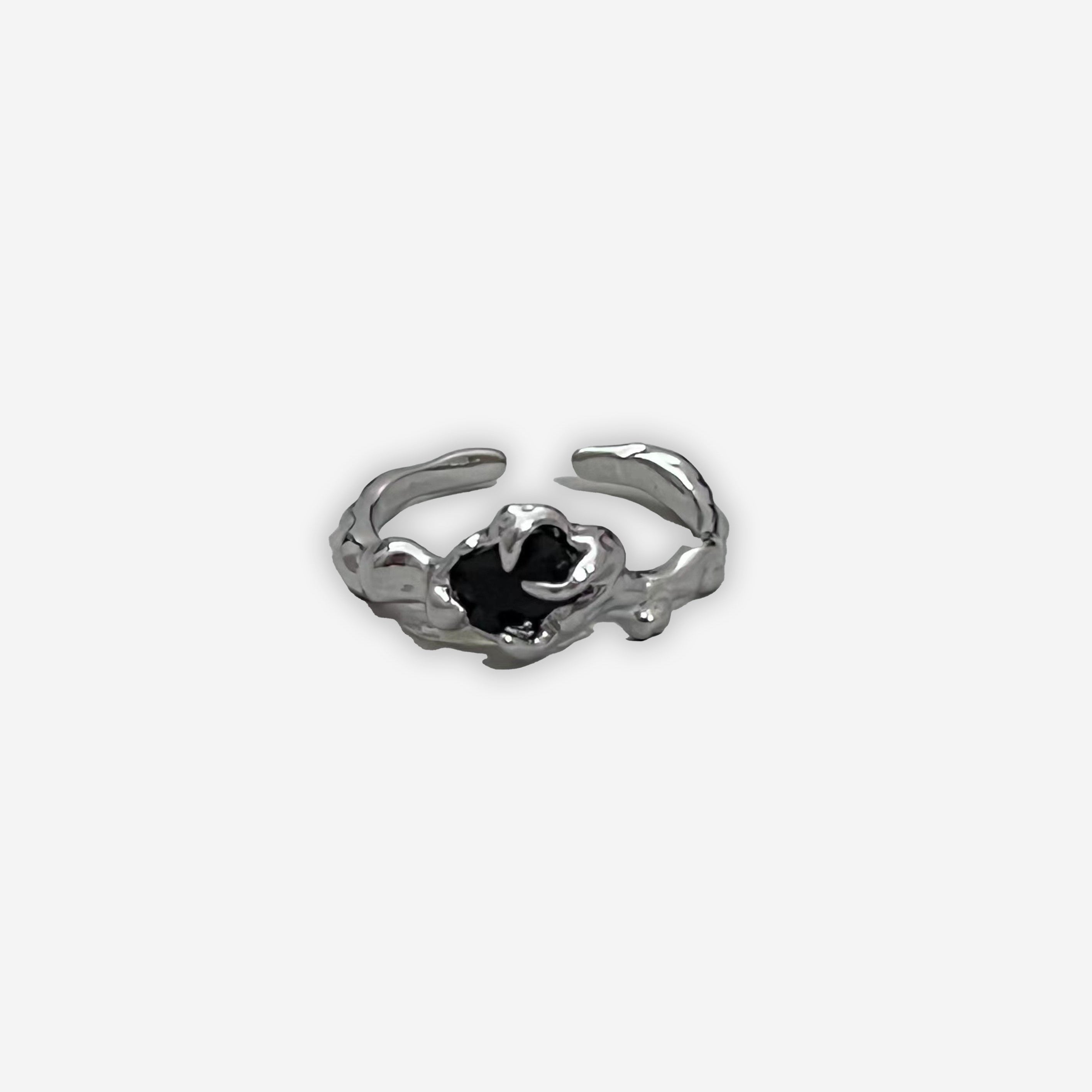 Close-up of a 2KWRLD claw ring featuring a detailed, edgy design with metallic finish on a plain background.