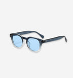 Calverton sunglasses by 2KWRLD featuring round frames and tinted lenses, displayed on a neutral background.