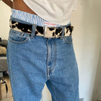 Black cow belt from 2KWRLD featuring adjustable strap and classic design, suitable for casual or Western-inspired outfits.