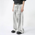 White Dirty Paint Denim jeans from 2KWRLD featuring a distressed, graffiti-inspired paint design and a slim fit style.
