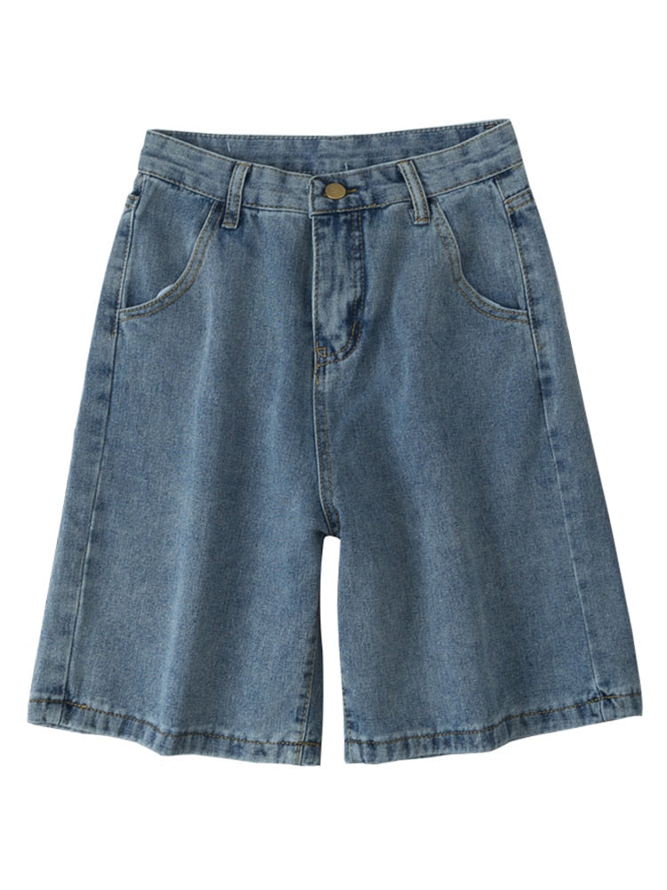 Light blue retro jorts denim shorts by 2KWRLD with distressed details and frayed hem, styled with rolled cuffs.